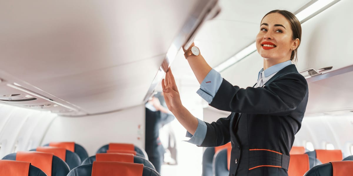 Hôtesse de l'air ouvrant un compartiment à bagages dans un avion